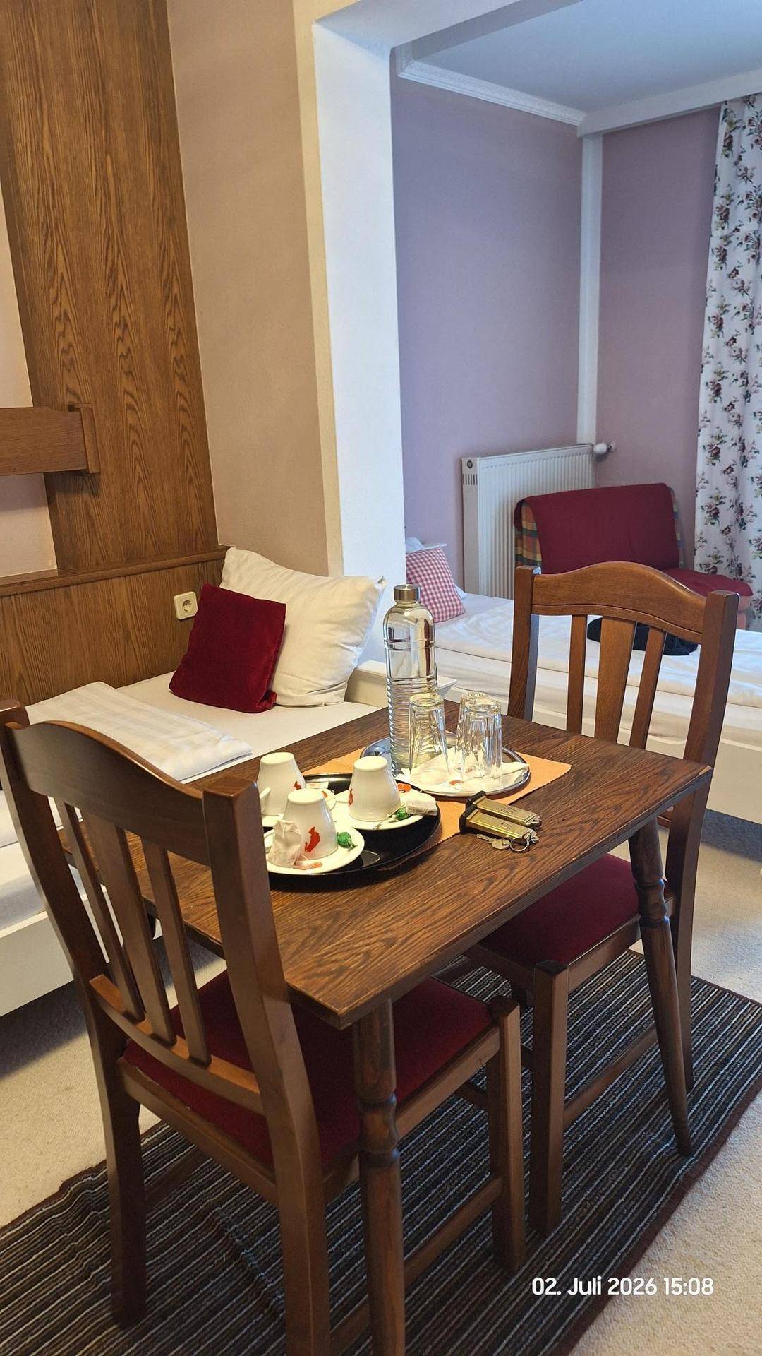 Schlafzimmer mit zwei Einzelbetten und einem kleinen Esstisch mit Stühlen für Mahlzeiten.