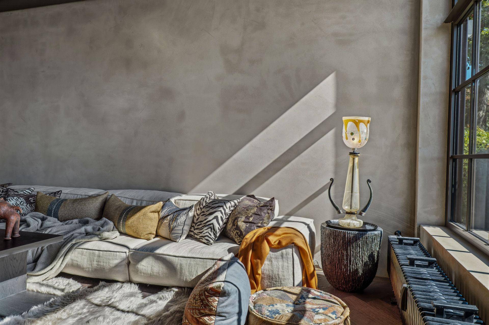 Detailansicht des Sofas im Wohnzimmer, beleuchtet durch natürliches Licht vom großen Fenster.