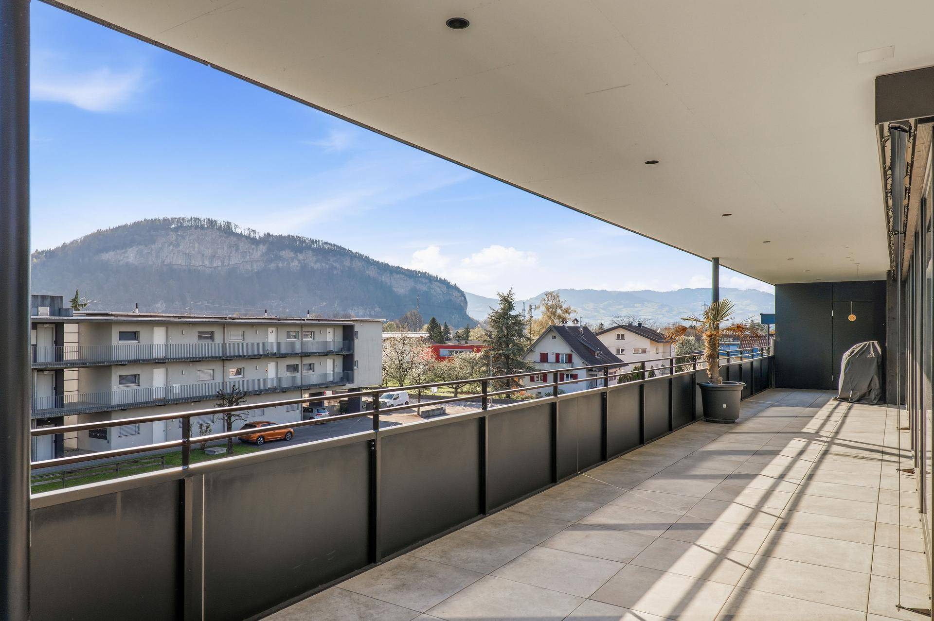 Langer überdachter Balkon mit Bergblick und viel Platz zum Entspannen.