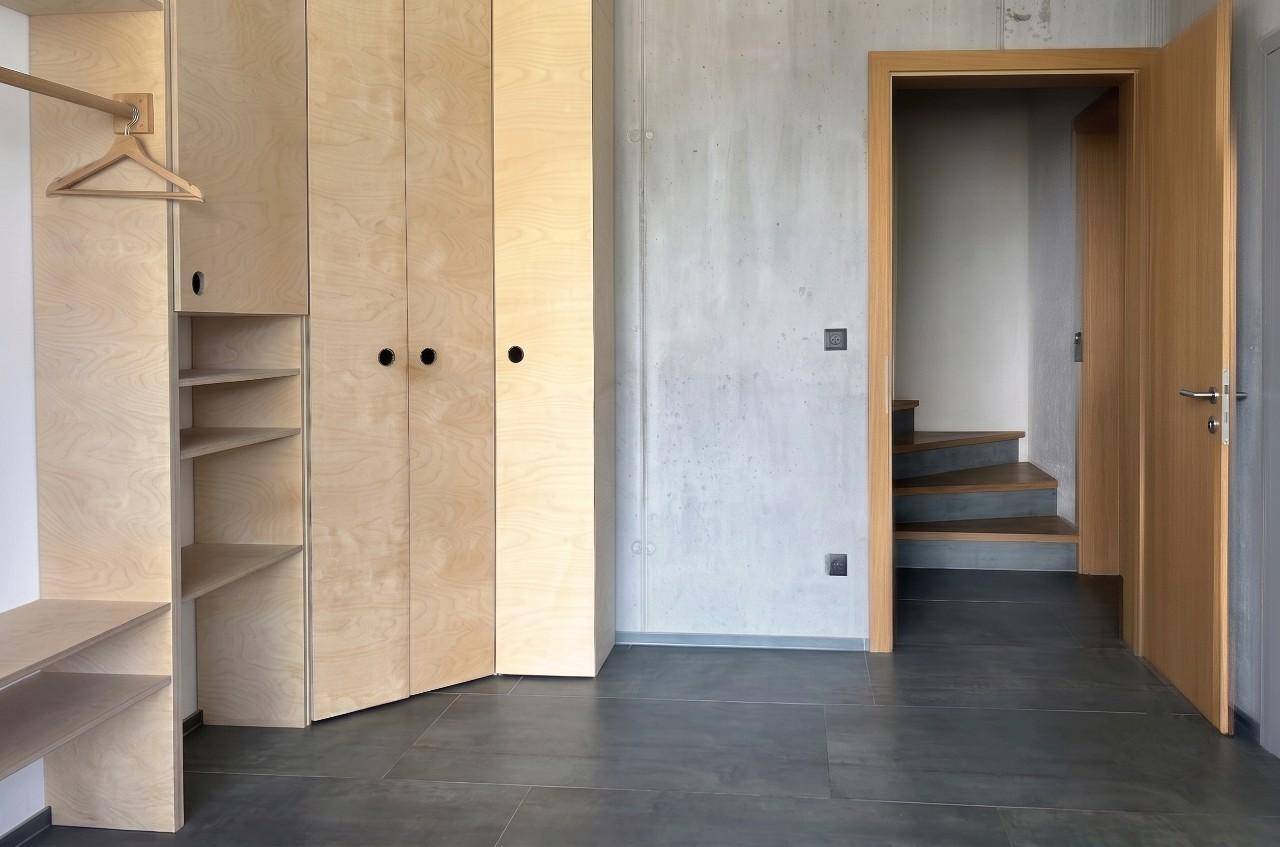 Heller Flur mit Einbauschränken aus hellem Holz und modernem Fliesenboden.