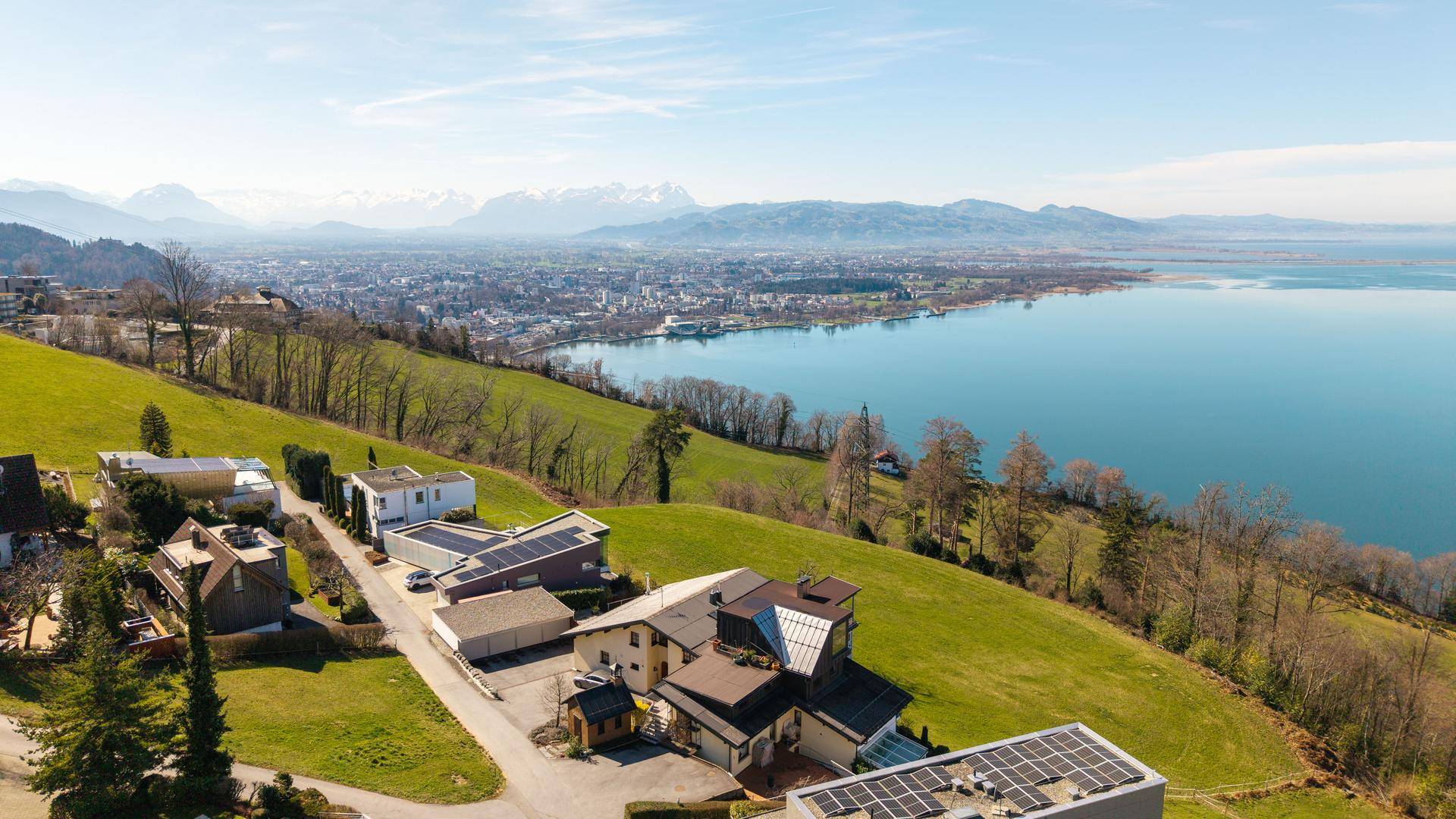 Weitläufiger Panoramablick über den See, die Stadt und die majestätischen Berge im Hintergrund.