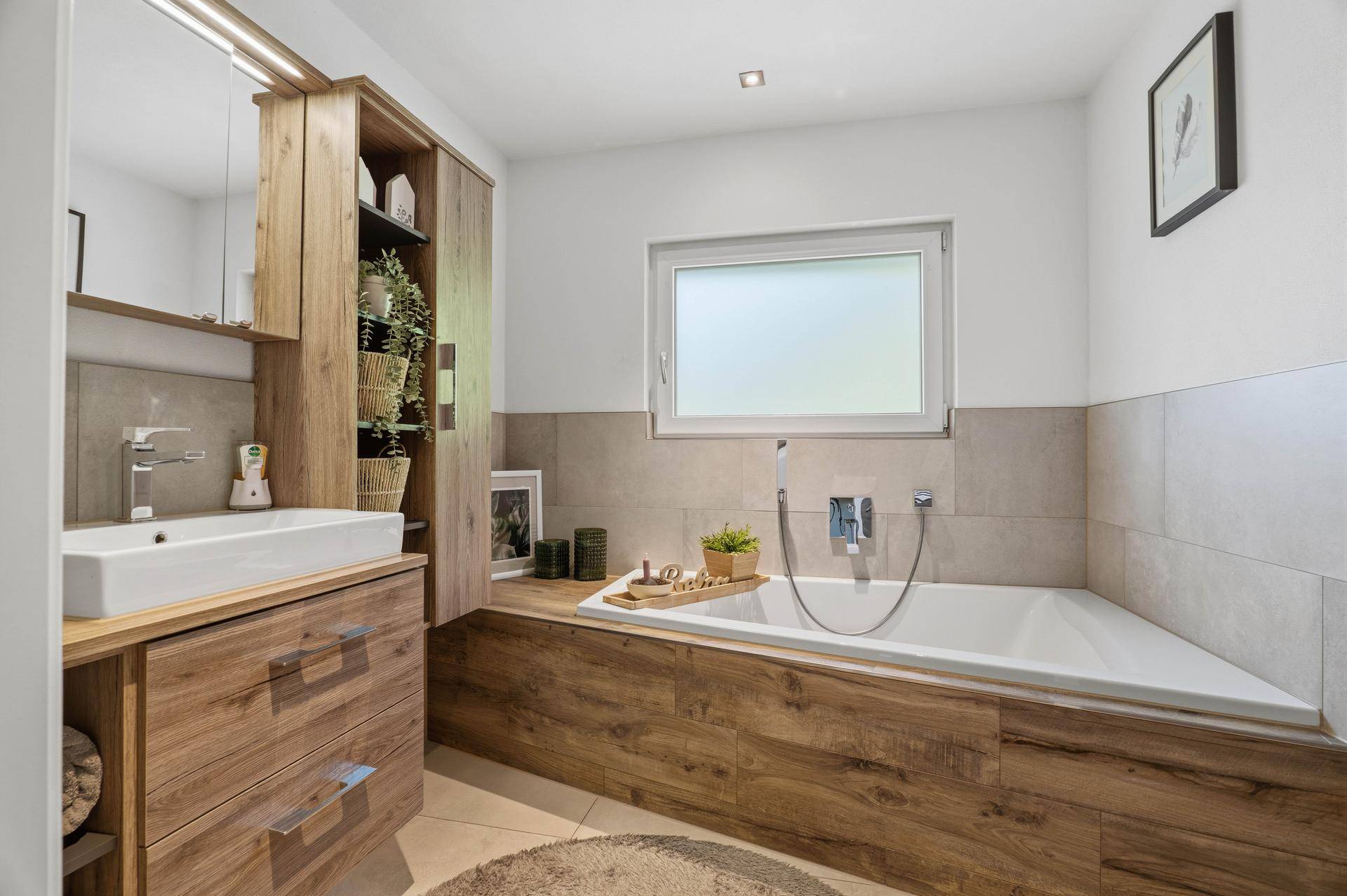 Helles Badezimmer mit Badewanne, Holzwaschtisch und großem Spiegel.