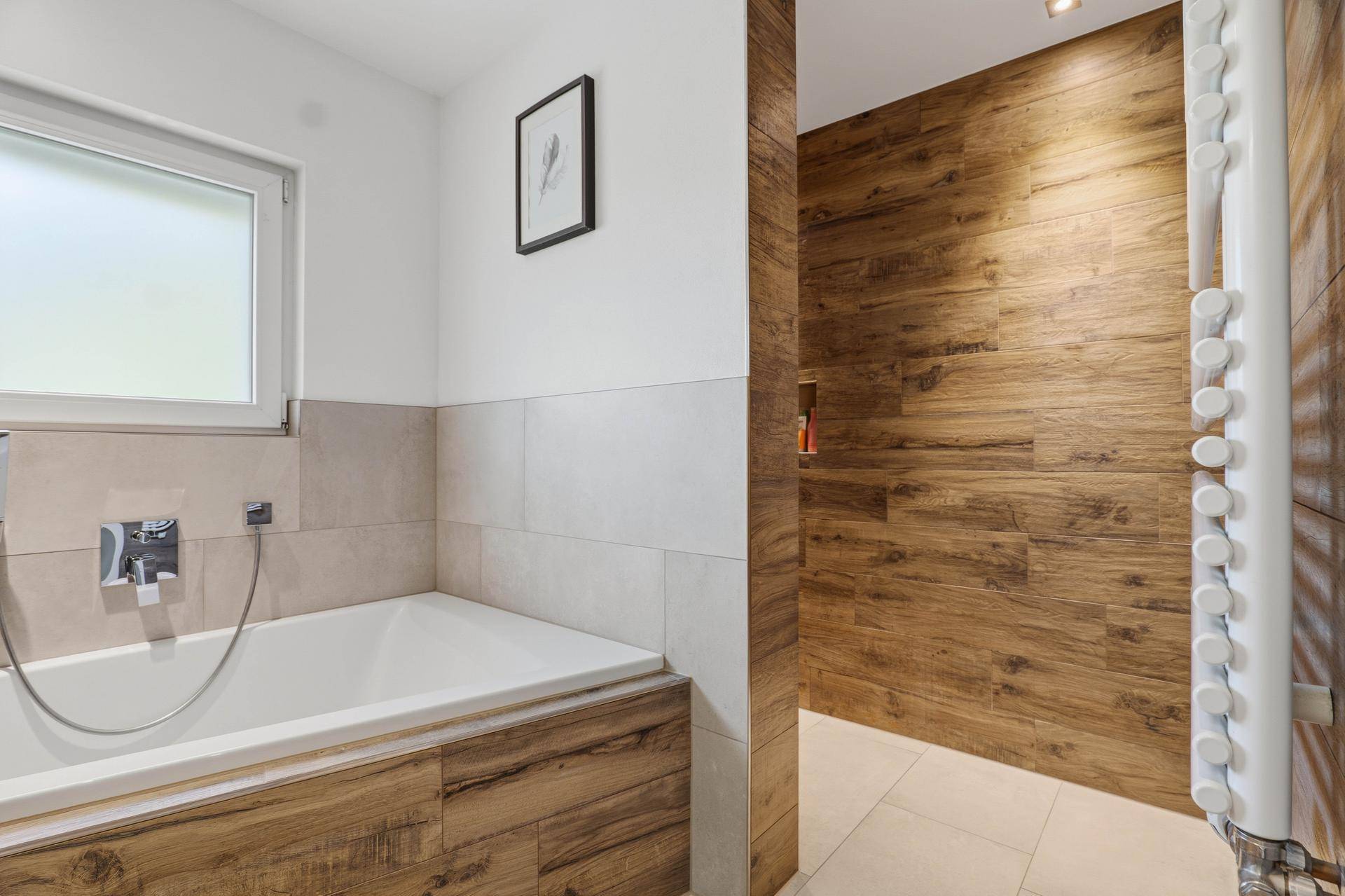 Modernes Badezimmer mit Badewanne, begehbarer Dusche und Holzverkleidung.