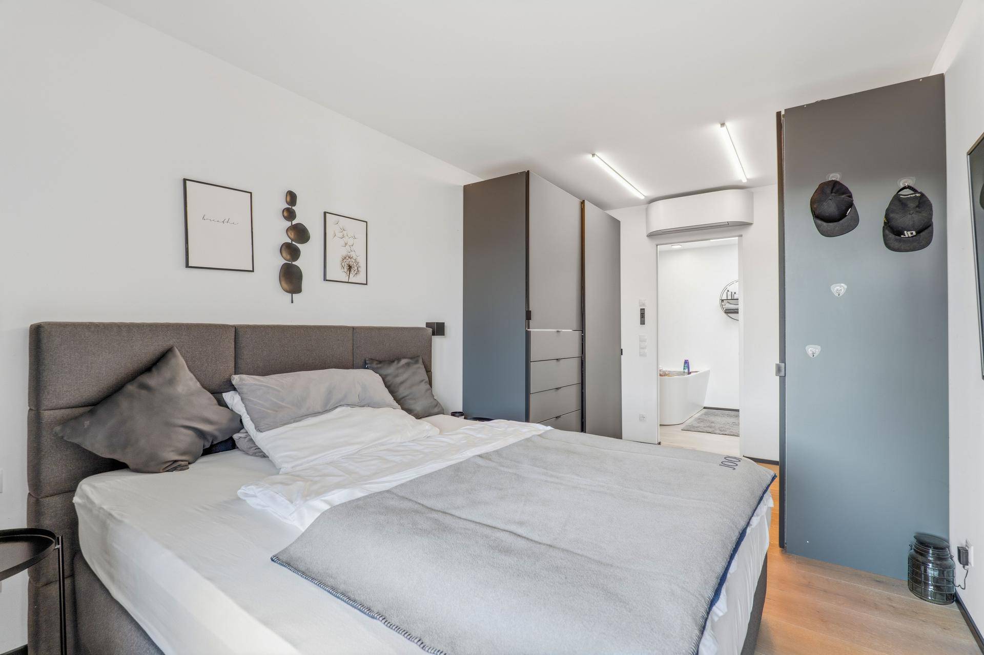 Gemütliches Schlafzimmer mit großem Bett, Einbauschränken und Zugang zum Bad.