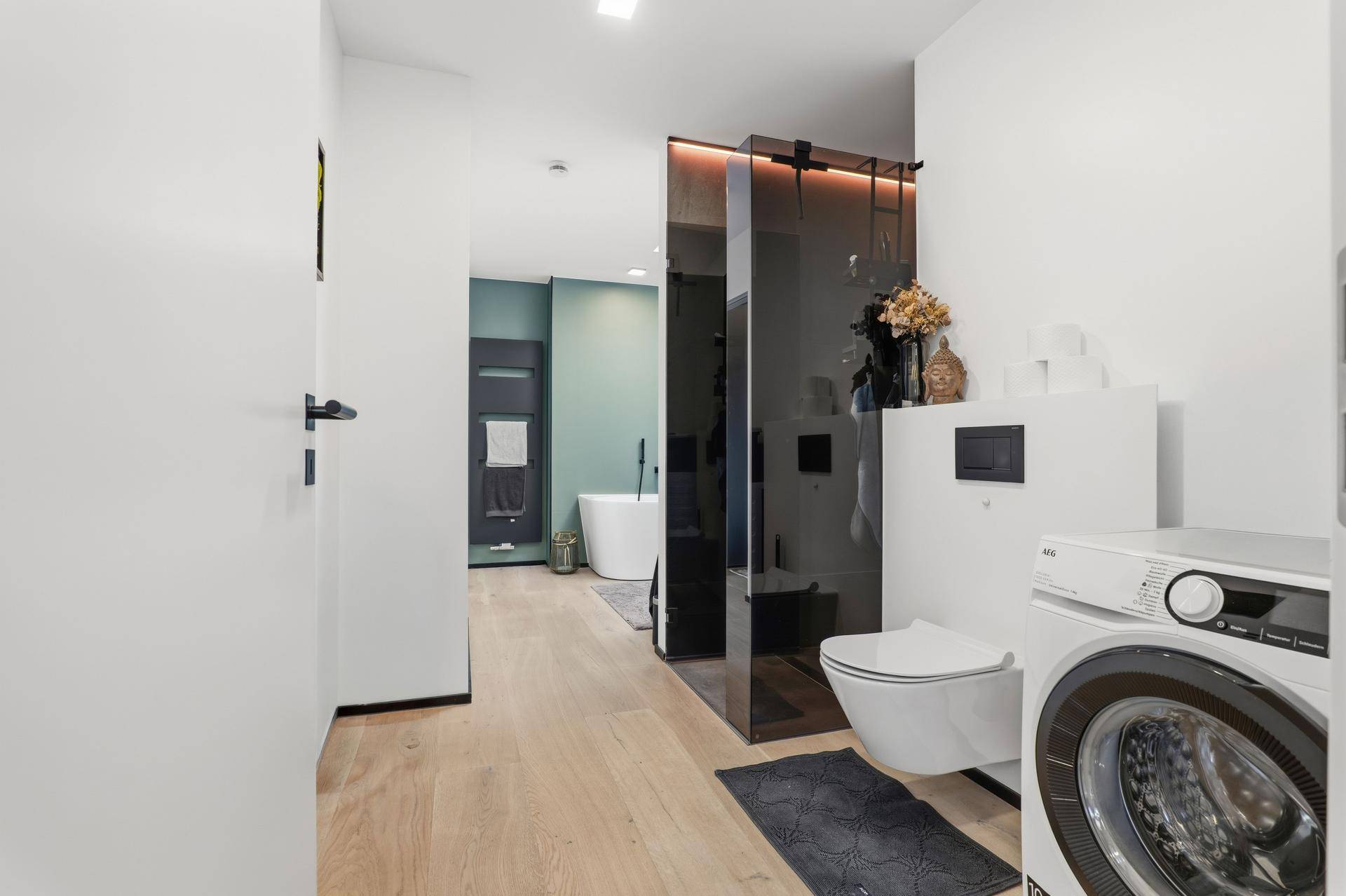 Modernes Badezimmer mit freistehender Badewanne, Dusche und Waschmaschine.