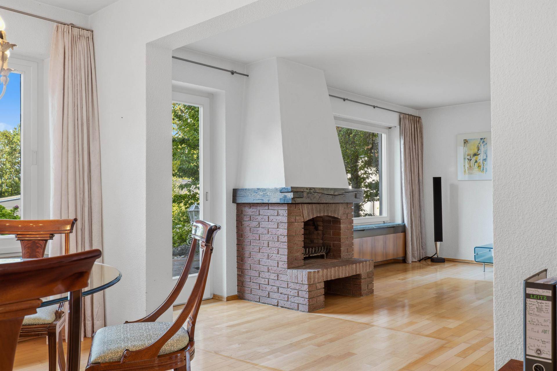 Gemütlicher Wohnbereich mit gemauertem Kamin und Holzboden, ideal für entspannte Stunden.
