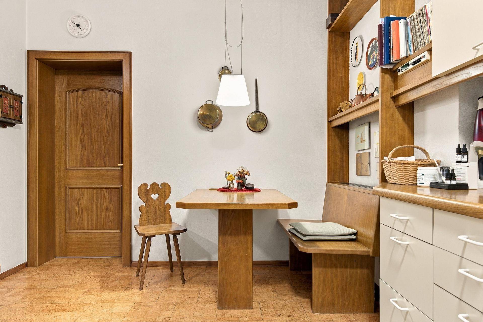 Gemütlicher Essbereich in der Küche mit Holztisch, Eckbank und traditionellem Stuhl.