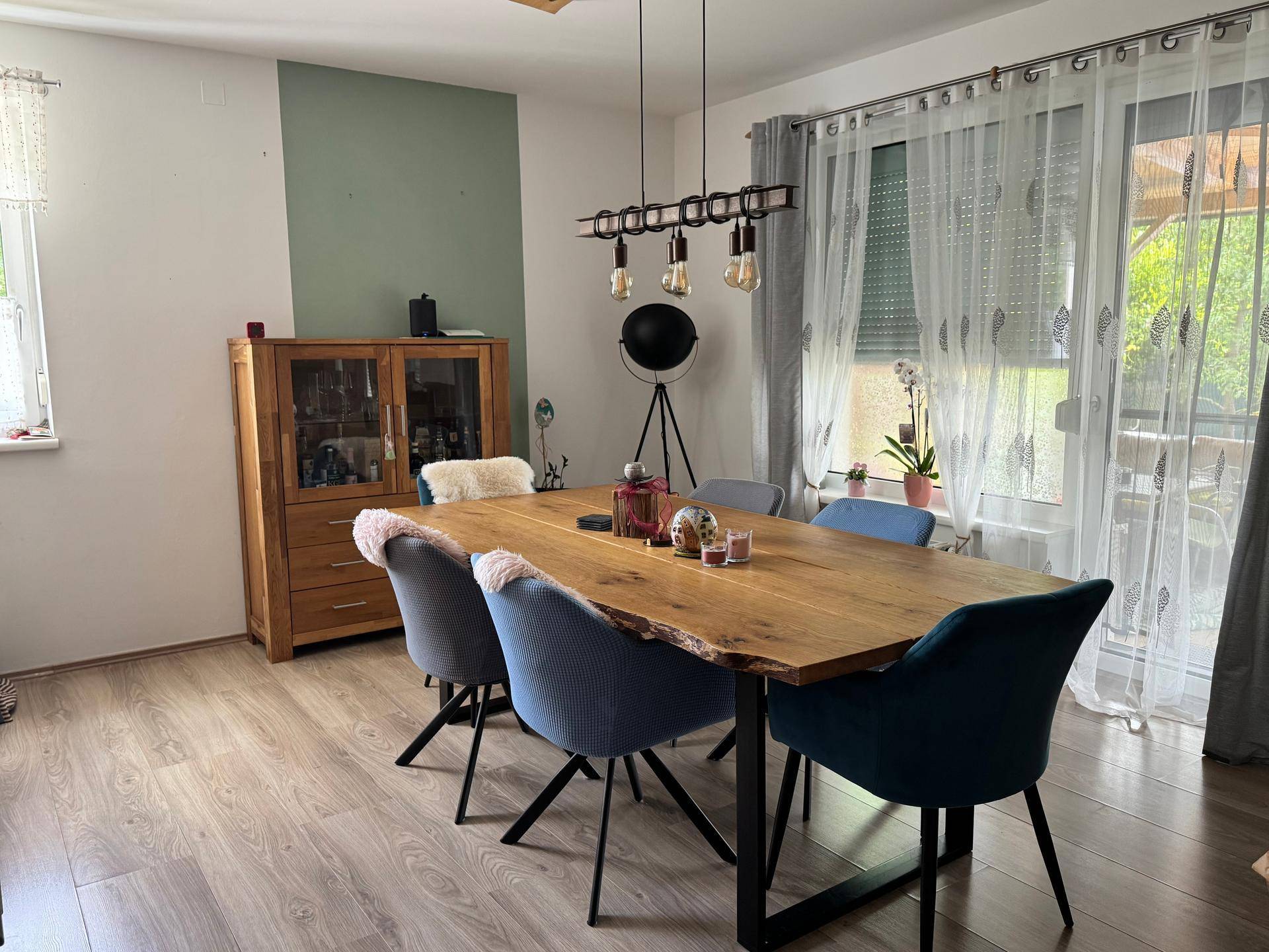 Geräumiger Essbereich mit großem Holztisch und Zugang zum Außenbereich, ideal für Familienessen.