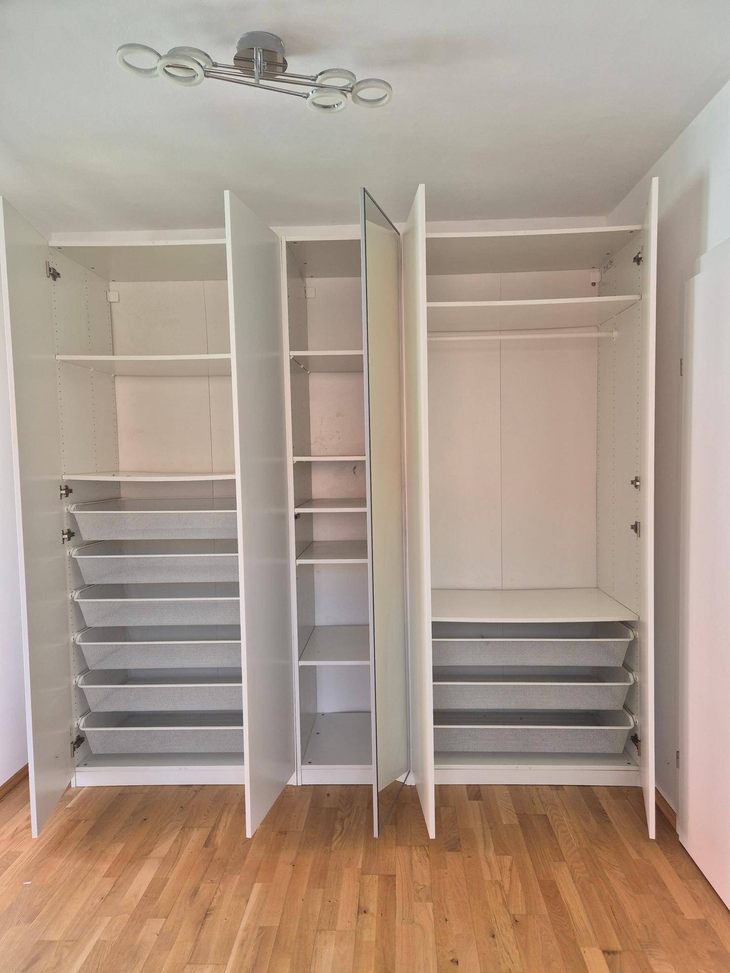 Offener Einbauschrank im Schlafzimmer mit viel Stauraum, Regalen und Kleiderstangen.