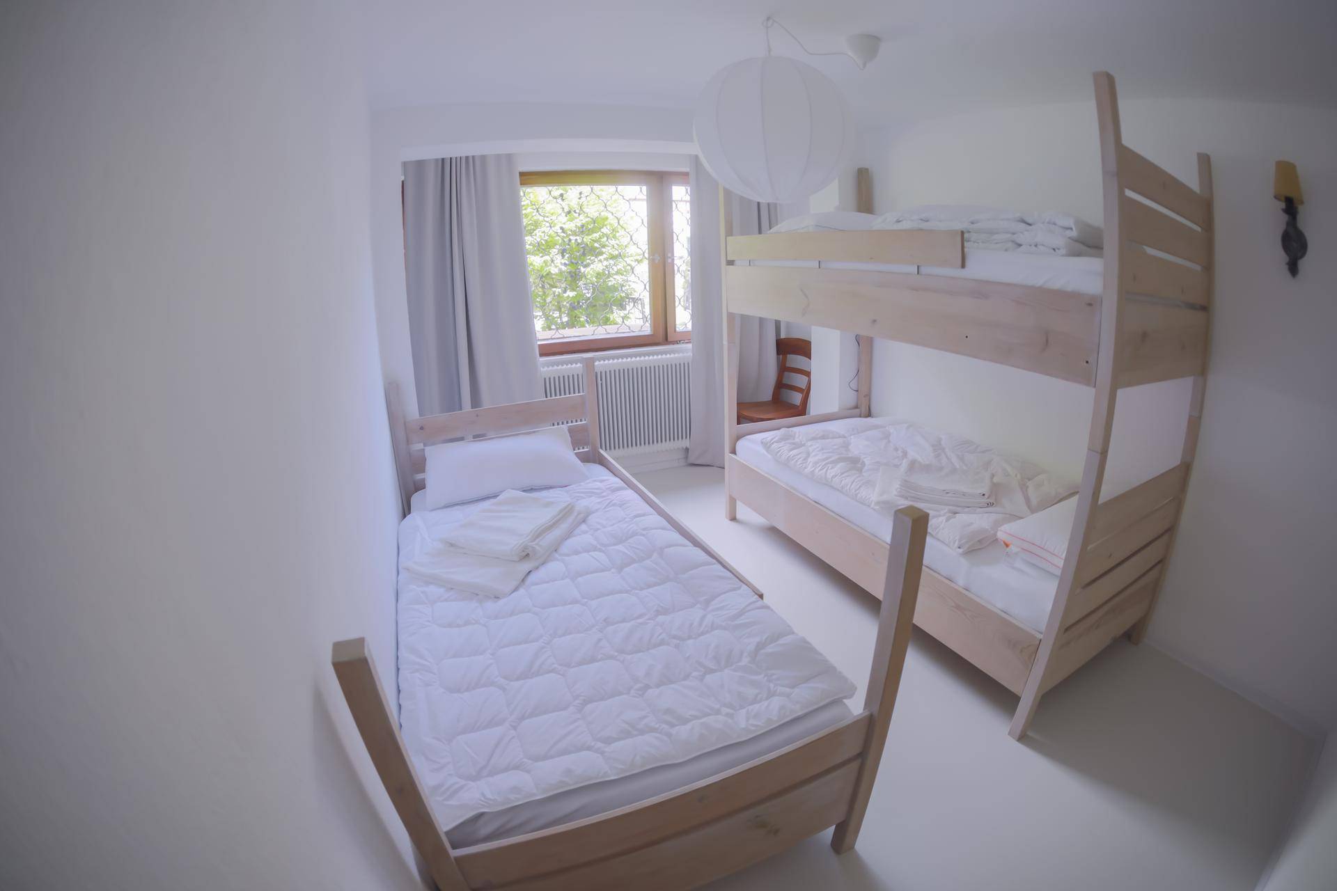 Helles Schlafzimmer mit Etagenbett und Einzelbett, ideal für Kinder oder Gäste.