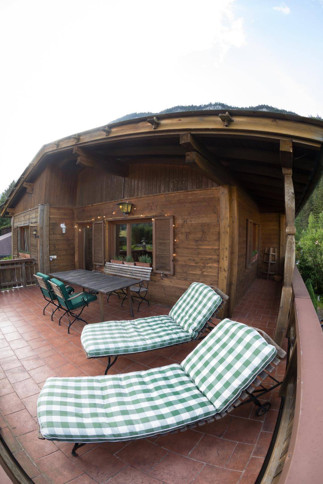 Weitläufige Terrasse mit Liegestühlen und Blick auf die umliegende Berglandschaft.