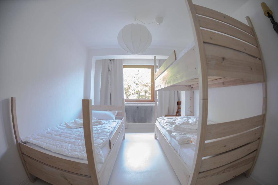 Helles Schlafzimmer mit Etagenbett und Einzelbett, ideal für Kinder oder Gäste.