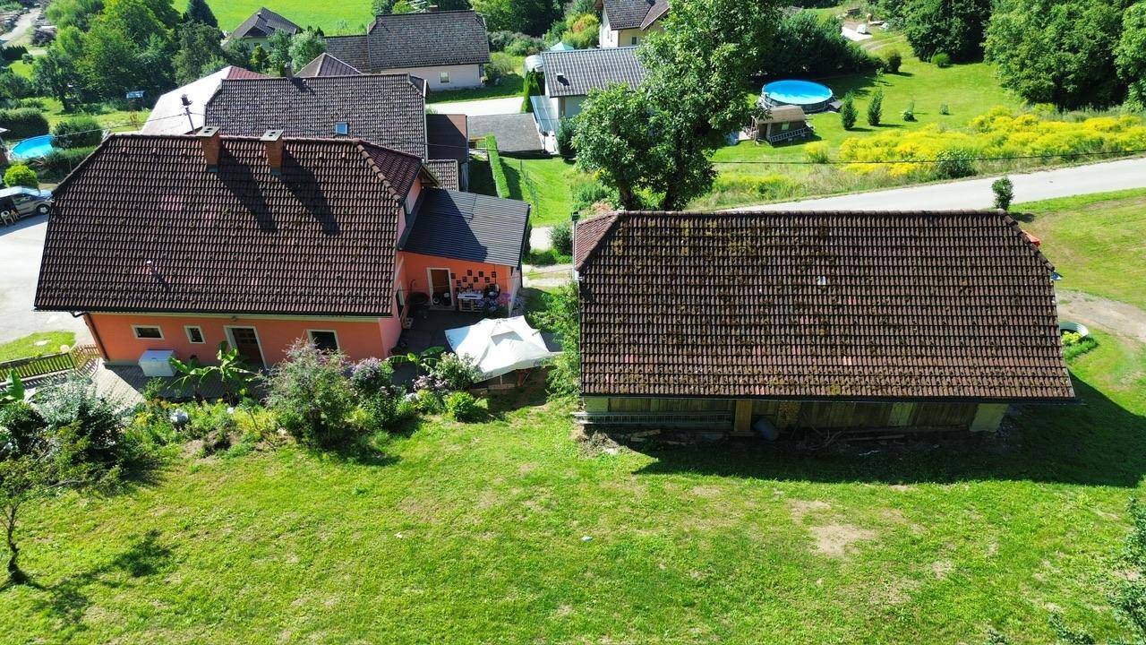 Zwei Häuser mit großem Rasenbereich, umgeben von ländlicher Natur und Bäumen.