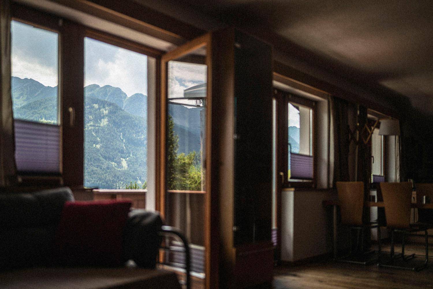Gemütliches Wohnzimmer mit großen Fenstern, die einen atemberaubenden Blick auf die Berge bieten.