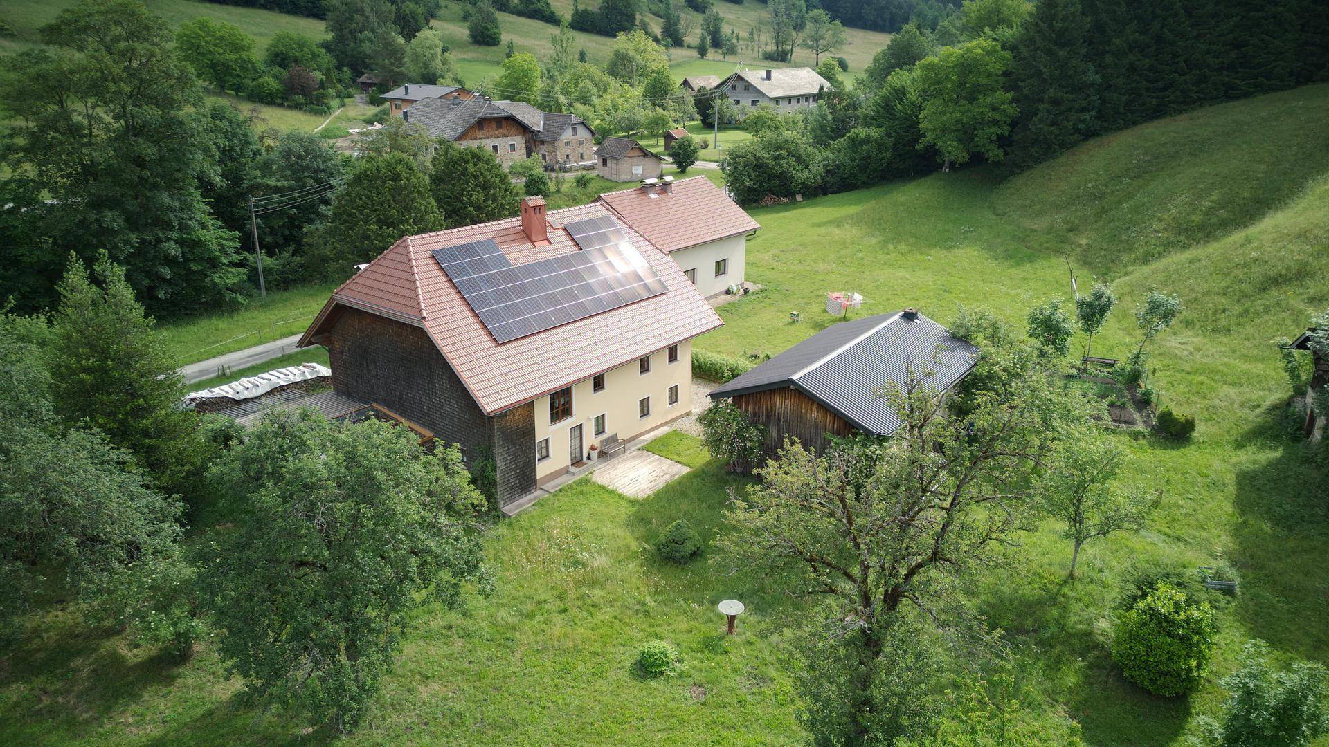 Weitläufiges Anwesen mit Haupthaus und Nebengebäude, eingebettet in eine grüne Landschaft.