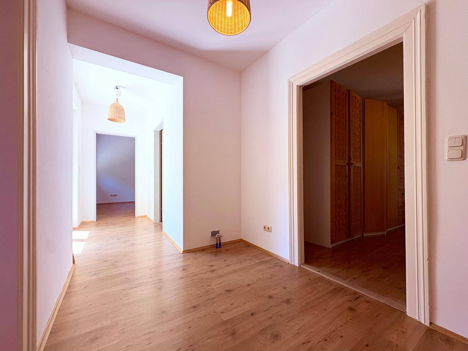 Heller Flur mit Holzboden, der zu weiteren Räumen im Haus führt.