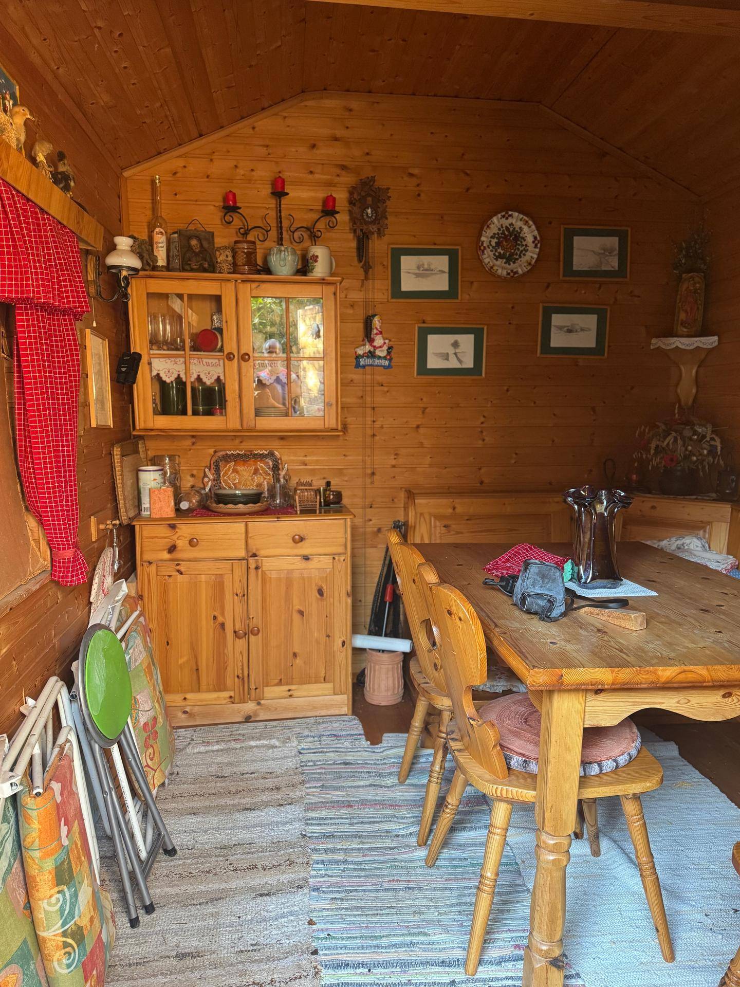 Gemütlicher Essbereich im Holzgartenhaus mit rustikalen Möbeln und Holzwänden, traditionell eingerichtet.