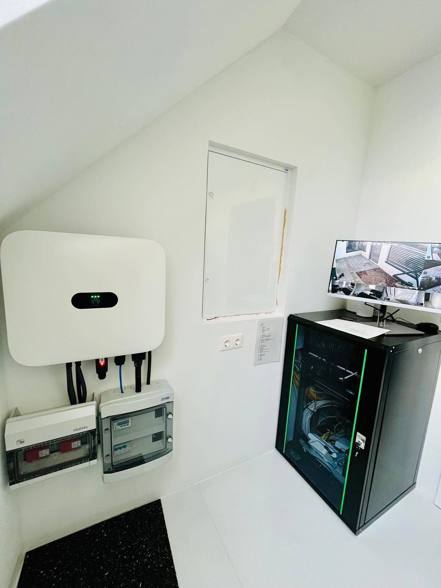 Technikraum mit Photovoltaik-Wechselrichter, Elektroverteilung und Netzwerkschrank für die Haustechnik.