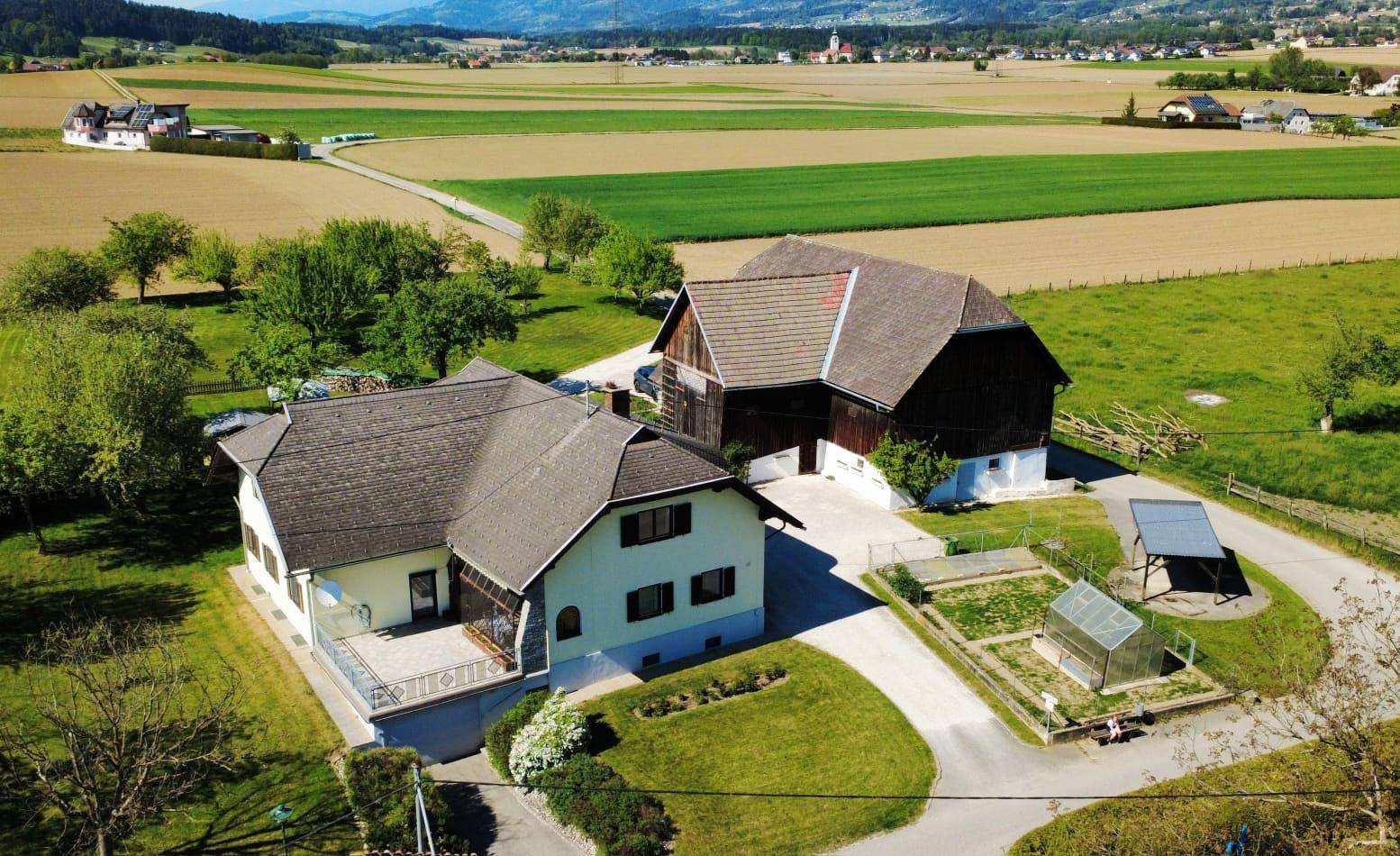 Luftaufnahme des Anwesens mit Wohnhaus, Scheune und einem kleinen Gemüsegarten in ländlicher Idylle.