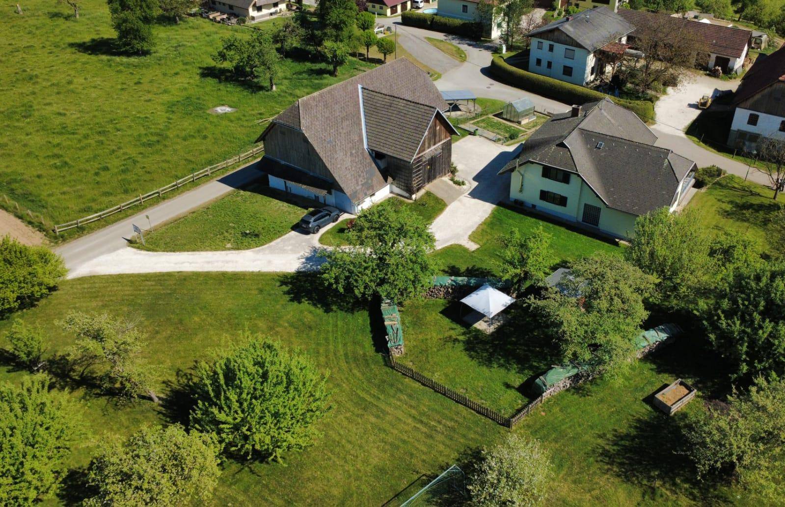 Vogelperspektive des weitläufigen Grundstücks mit Wohnhaus, Scheune und großem Rasenbereich in ländlicher Umgebung.