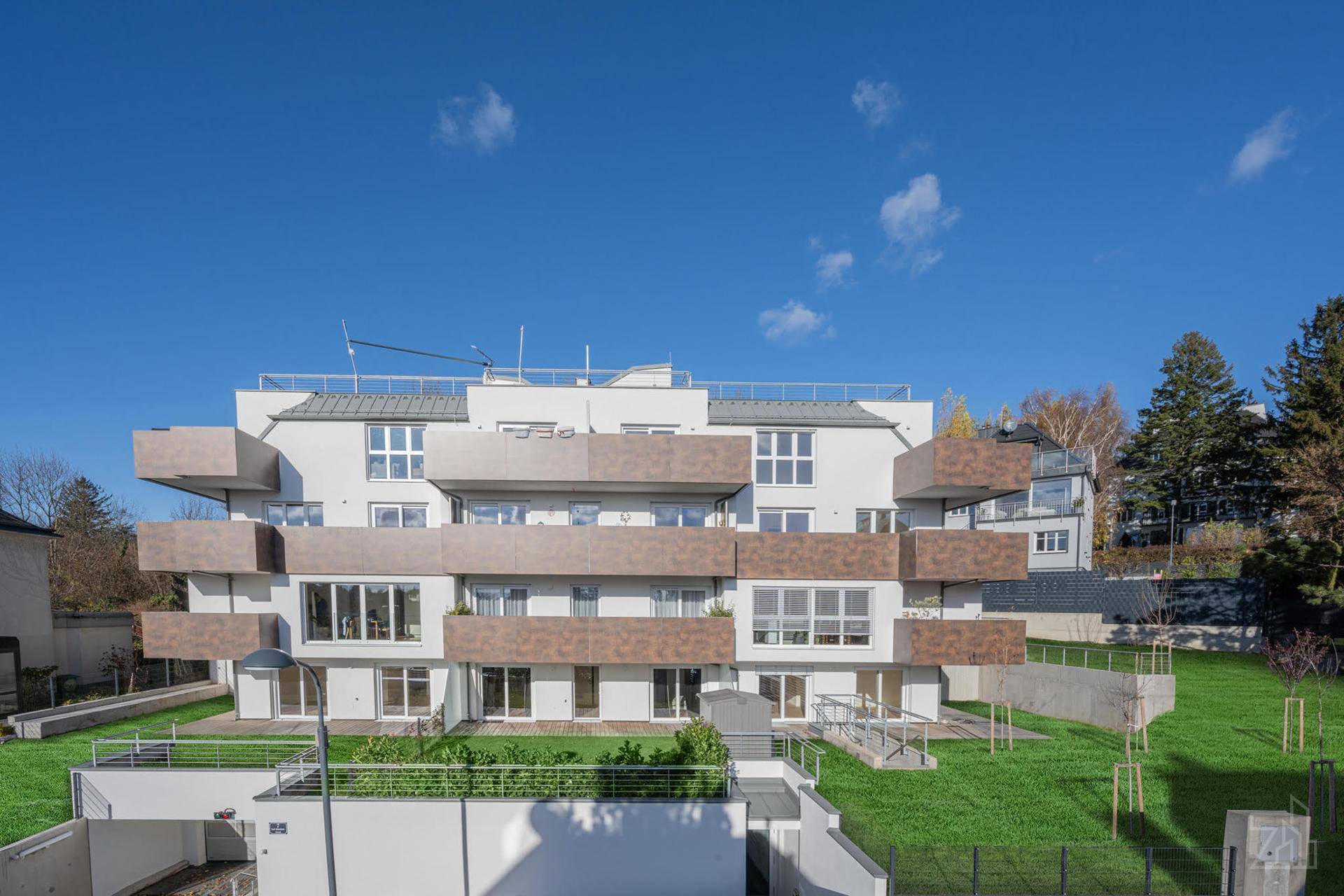 Moderne Wohnanlage mit gestuften Balkonen und gepflegten Grünflächen im Außenbereich.
