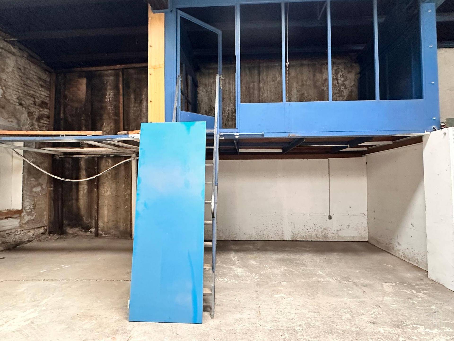 Detailansicht der blauen Mezzanine-Struktur mit Treppe und dem darunterliegenden Bereich.