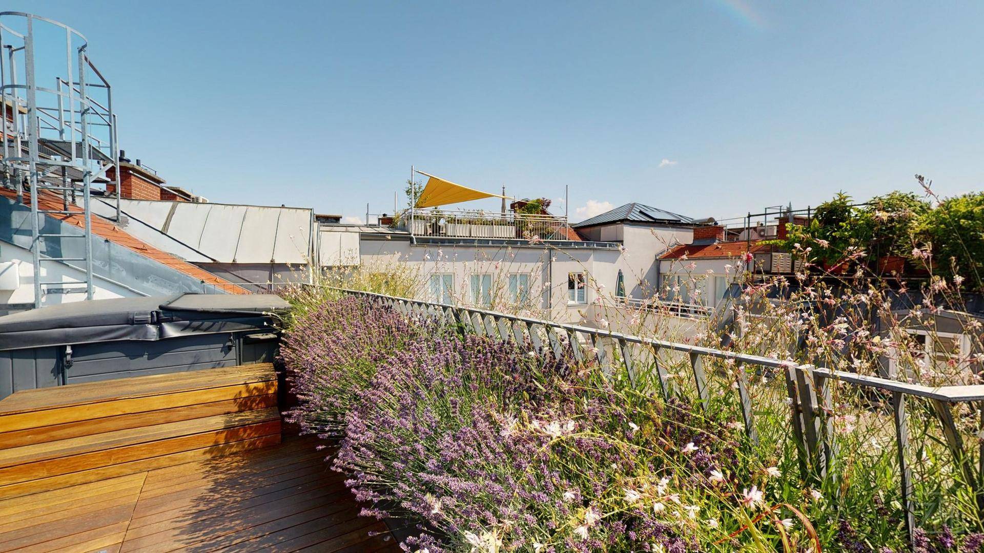 Dachterrasse mit Whirlpool, Holzdeck und üppiger Bepflanzung, ideal zum Entspannen.