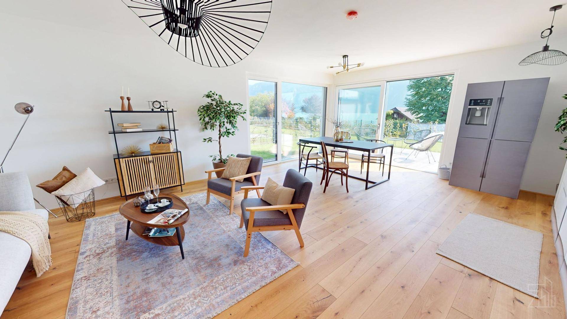 Geräumiger Wohn-Essbereich mit Holzboden, stilvoller Einrichtung und Blick auf den Garten und die Landschaft.