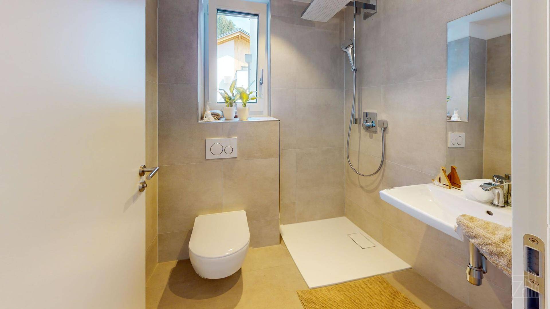 Modernes Badezimmer mit Dusche, Waschbecken, Wand-WC und Fenster für Tageslicht.