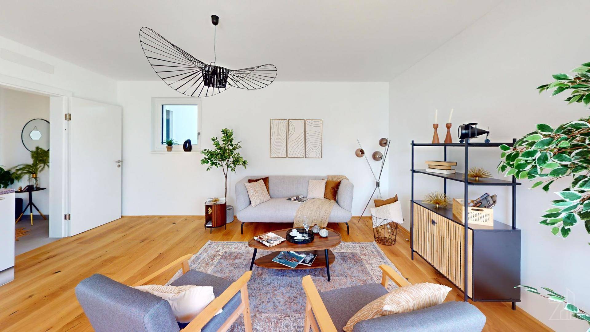 Gemütliches Wohnzimmer mit Holzboden, stilvoller Einrichtung und einem modernen Deckenventilator.