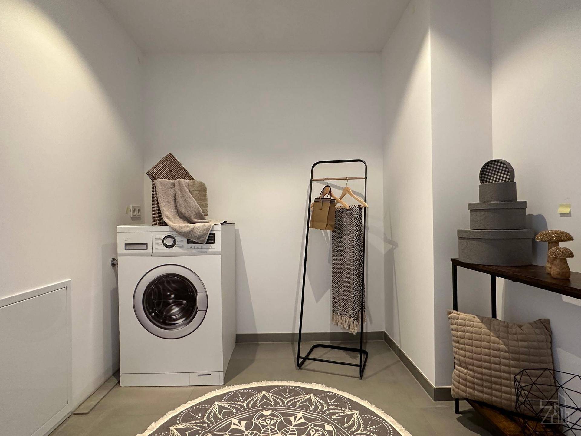 Praktischer Hauswirtschaftsraum mit Waschmaschine und ausreichend Platz für Wäsche.