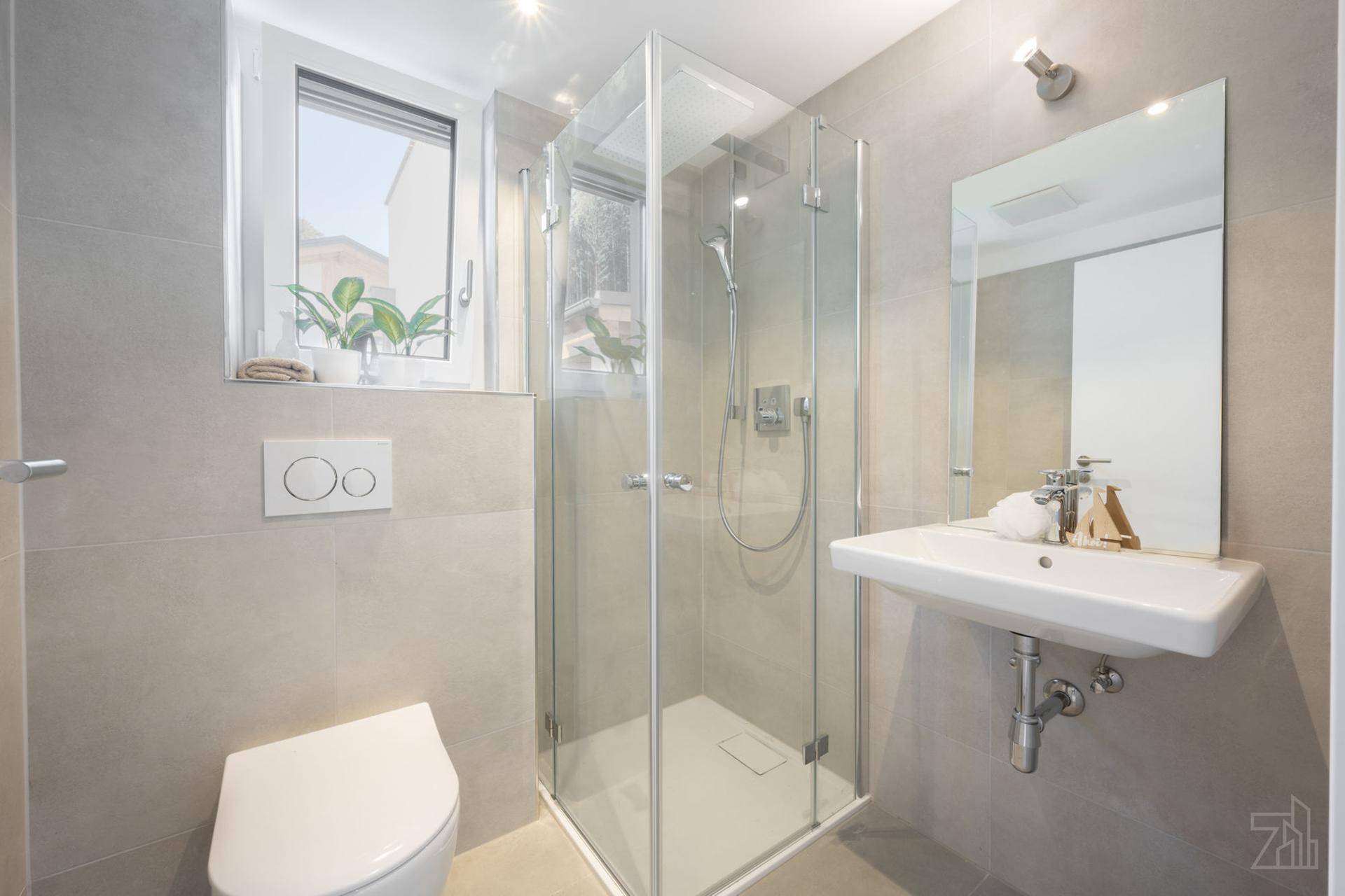 Modernes Badezimmer mit ebenerdiger Dusche, WC, Einzelwaschbecken und Fenster für Tageslicht.