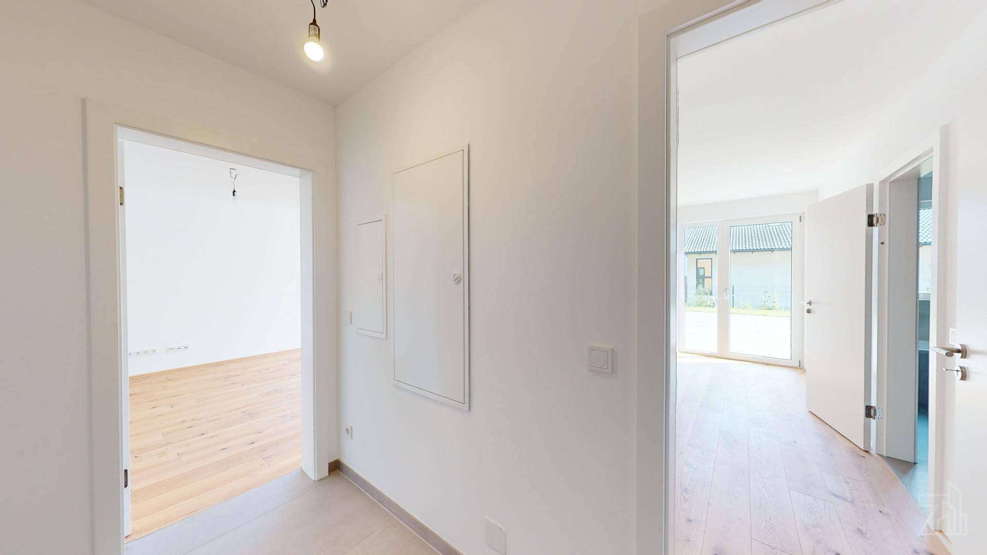 Heller Flur mit Holzboden und Zugang zu verschiedenen Zimmern, modern und funktional.
