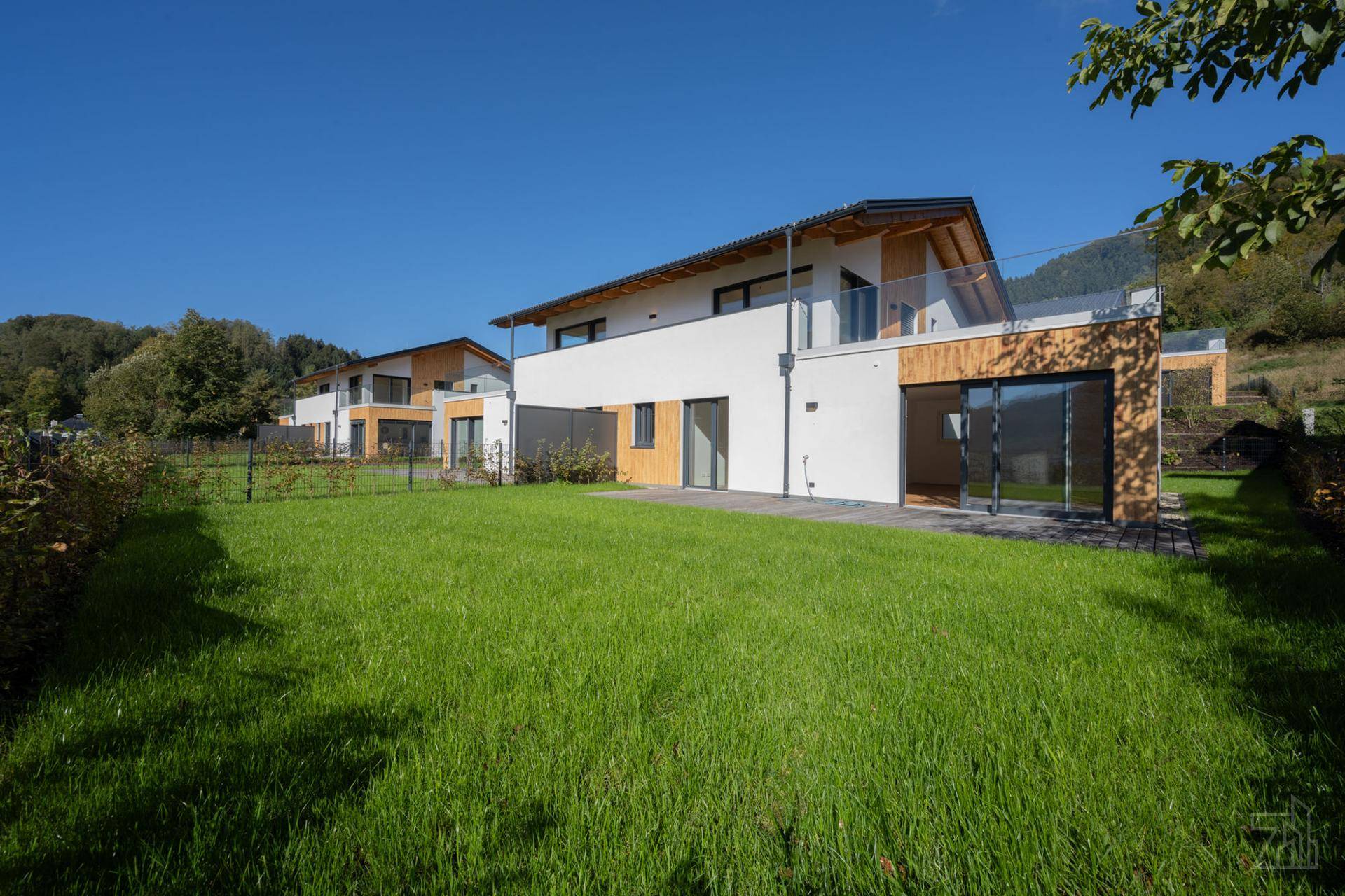 Moderne Häuser mit großzügiger Rasenfläche und zeitgenössischer Architektur.