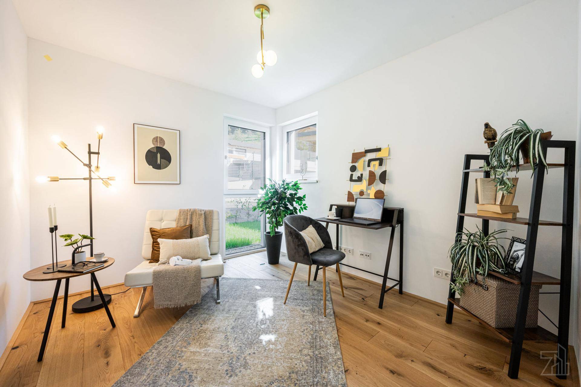 Helles Arbeitszimmer mit Schreibtisch, bequemen Stühlen und Holzboden, ideal für Home-Office.