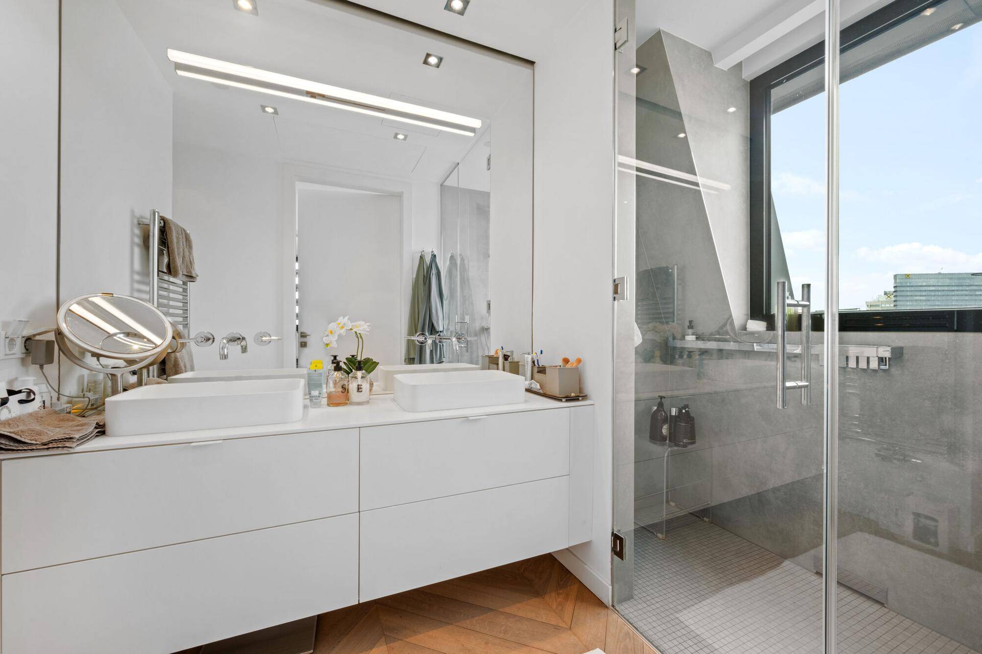 Modernes Badezimmer mit Doppelwaschbecken, großem Spiegel und begehbarer Dusche.