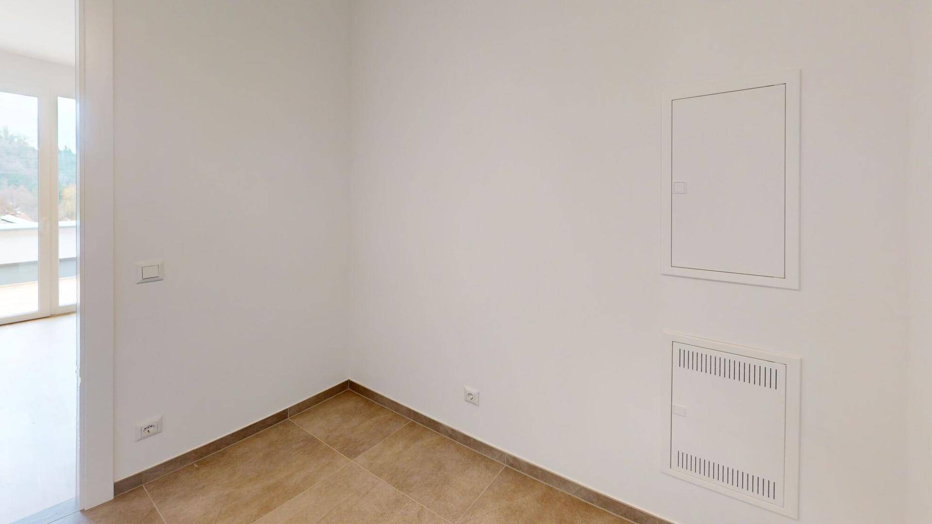 Kleiner Raum mit Fliesenboden und weißen Wänden, möglicherweise ein Abstellraum oder Flur.