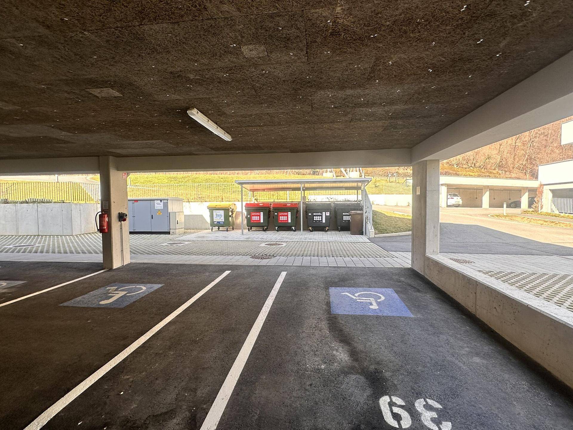 Tiefgarage mit Parkplätzen, barrierefreien Stellflächen und einem Bereich für Müllentsorgung.