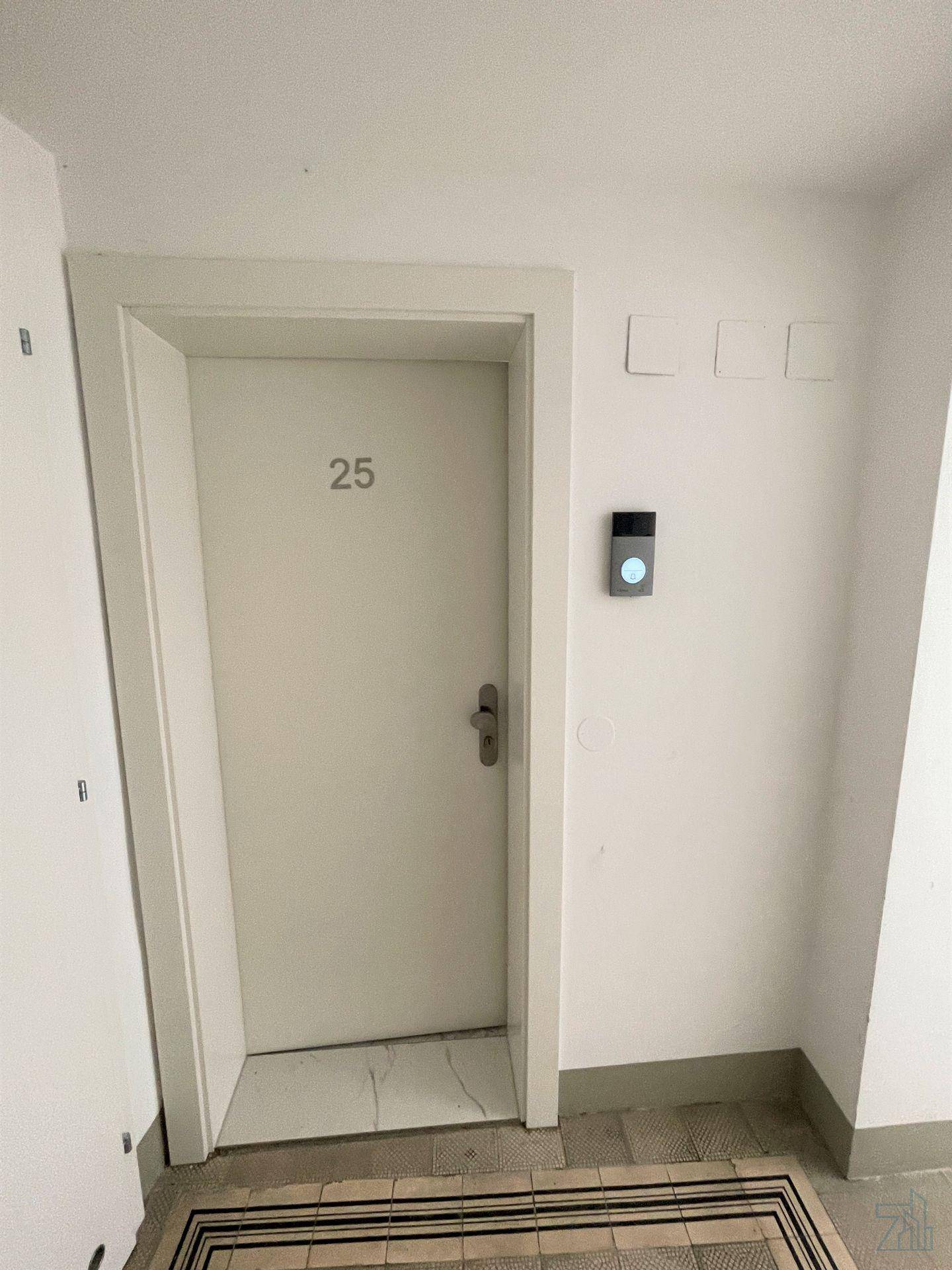 Eingangstür einer Wohnung mit der Nummer 25 und moderner Gegensprechanlage.