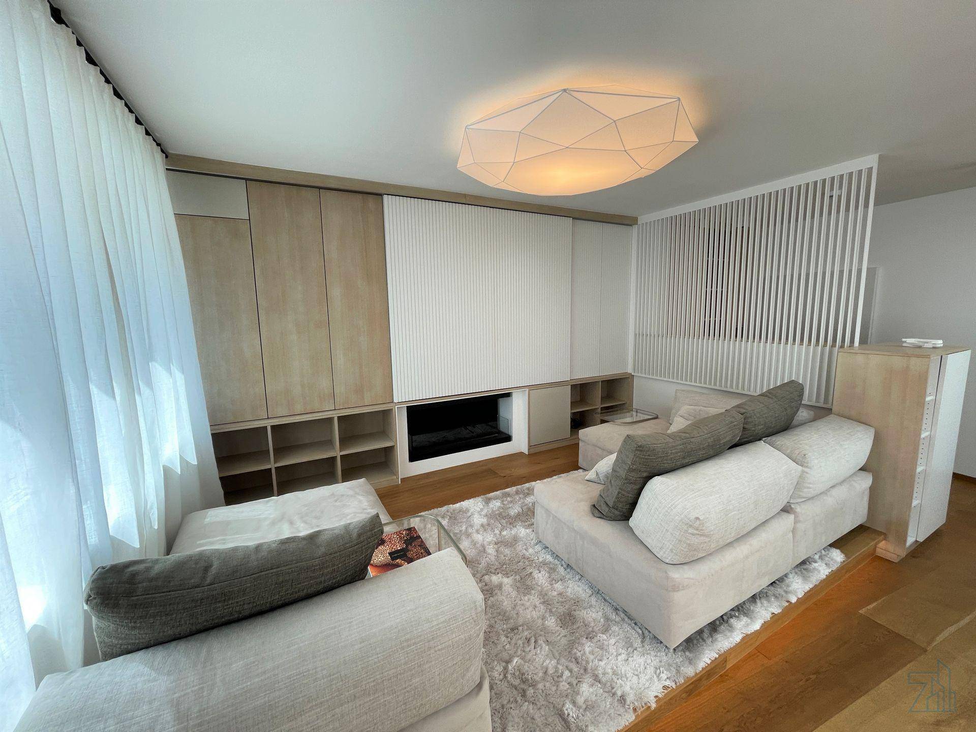 Gemütlicher Wohnbereich mit großem Sofa, integrierten Regalen und modernem Design.