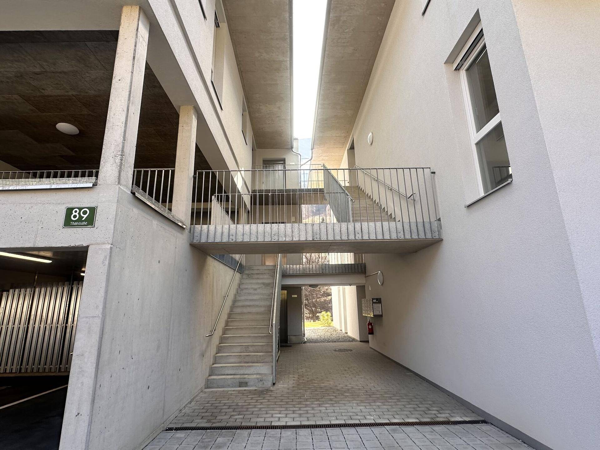 Eingangsbereich der Wohnanlage mit Treppen und Zugang zur Tiefgarage.