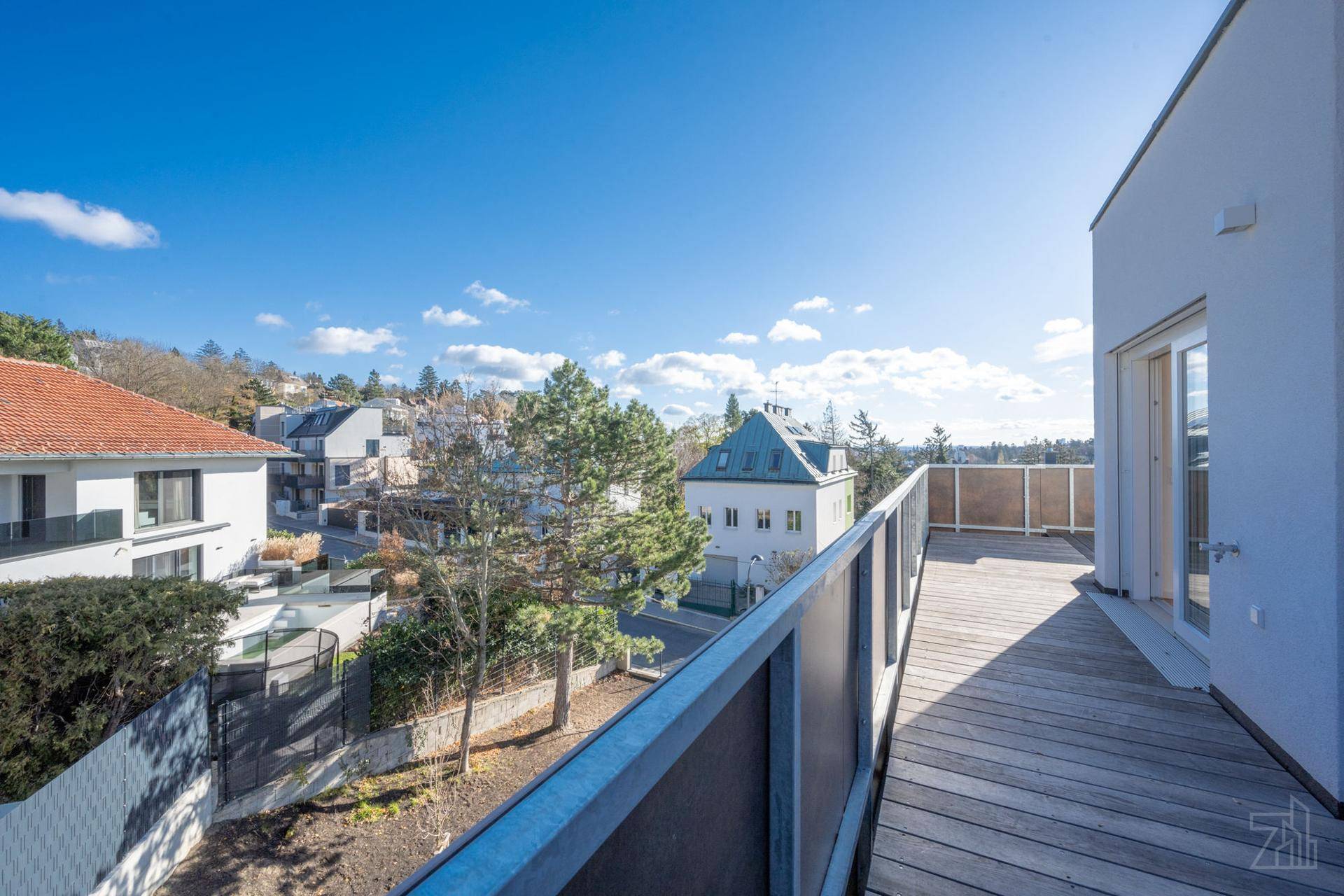 Geräumige Holzterrasse mit modernem Geländer und Blick auf die umliegende Wohngegend.