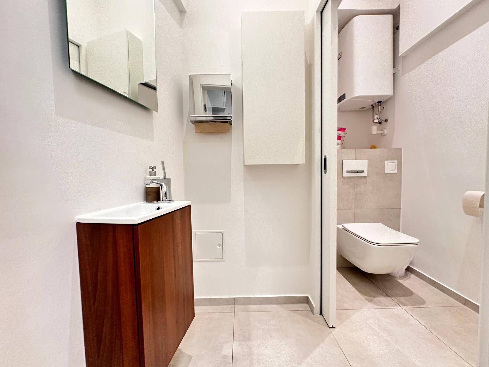 Modernes Gäste-WC mit wandhängender Toilette und Waschbecken.