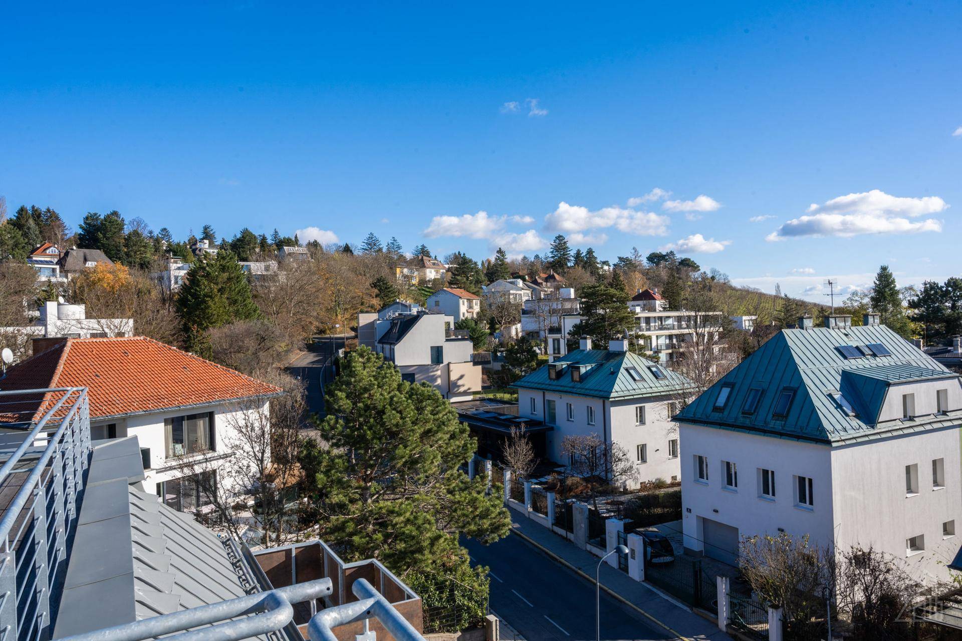 Panoramablick über eine ruhige Wohngegend mit vielfältiger Architektur und grünen Hügeln.