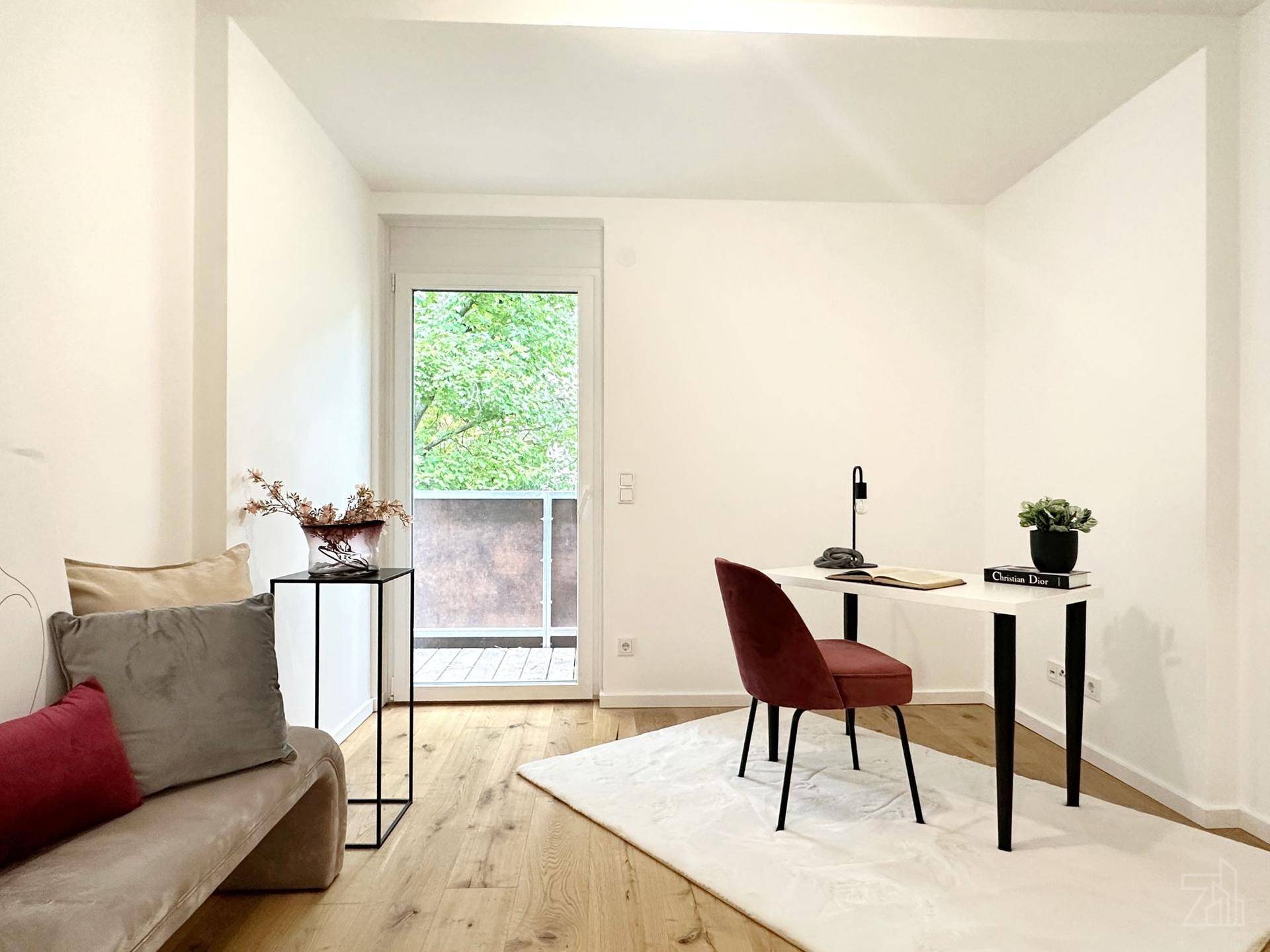 Helles Arbeitszimmer mit Schreibtisch, minimalistischer Einrichtung und Zugang zum Balkon.