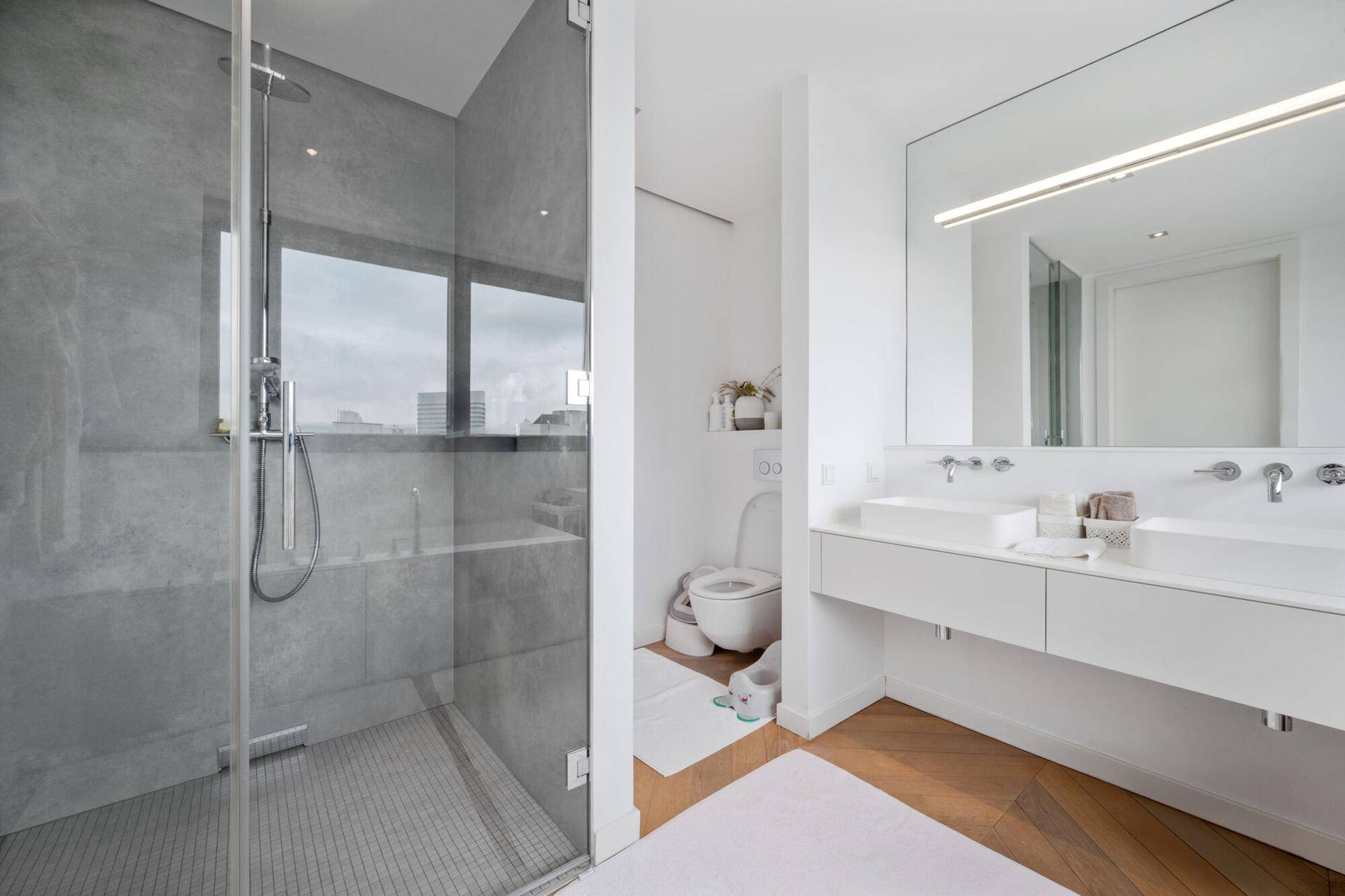 Modernes Badezimmer mit begehbarer Dusche, Doppelwaschbecken und Wand-WC.