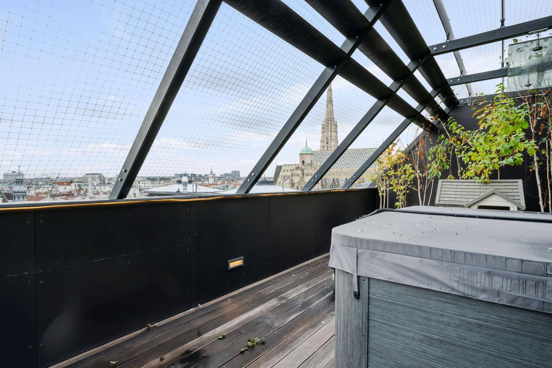 Dachterrasse mit modernem Whirlpool und weitem Blick über die Dächer der Stadt.