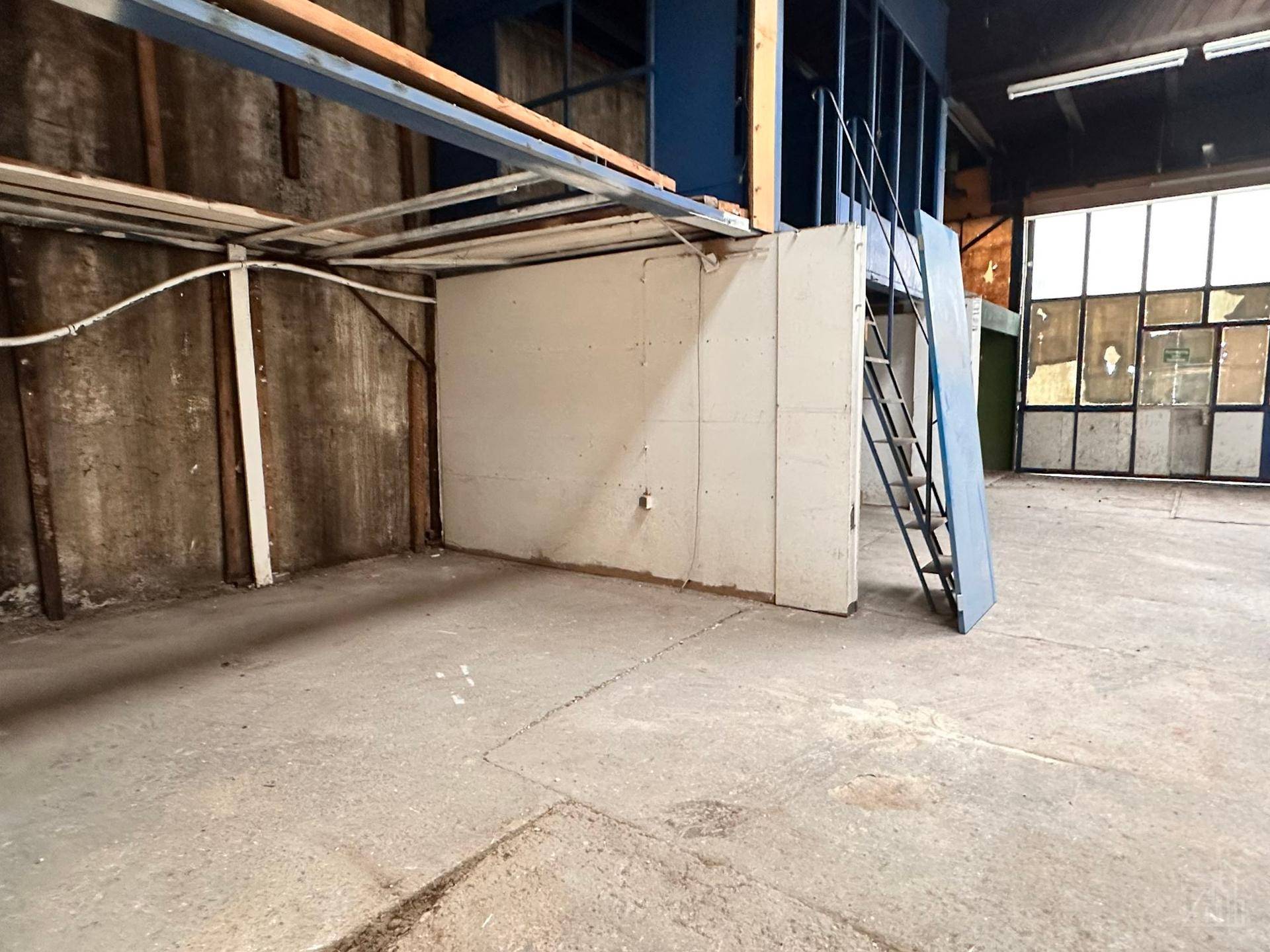 Blick auf die blaue Mezzanine-Struktur und die angrenzende Wand im Lagerraum.