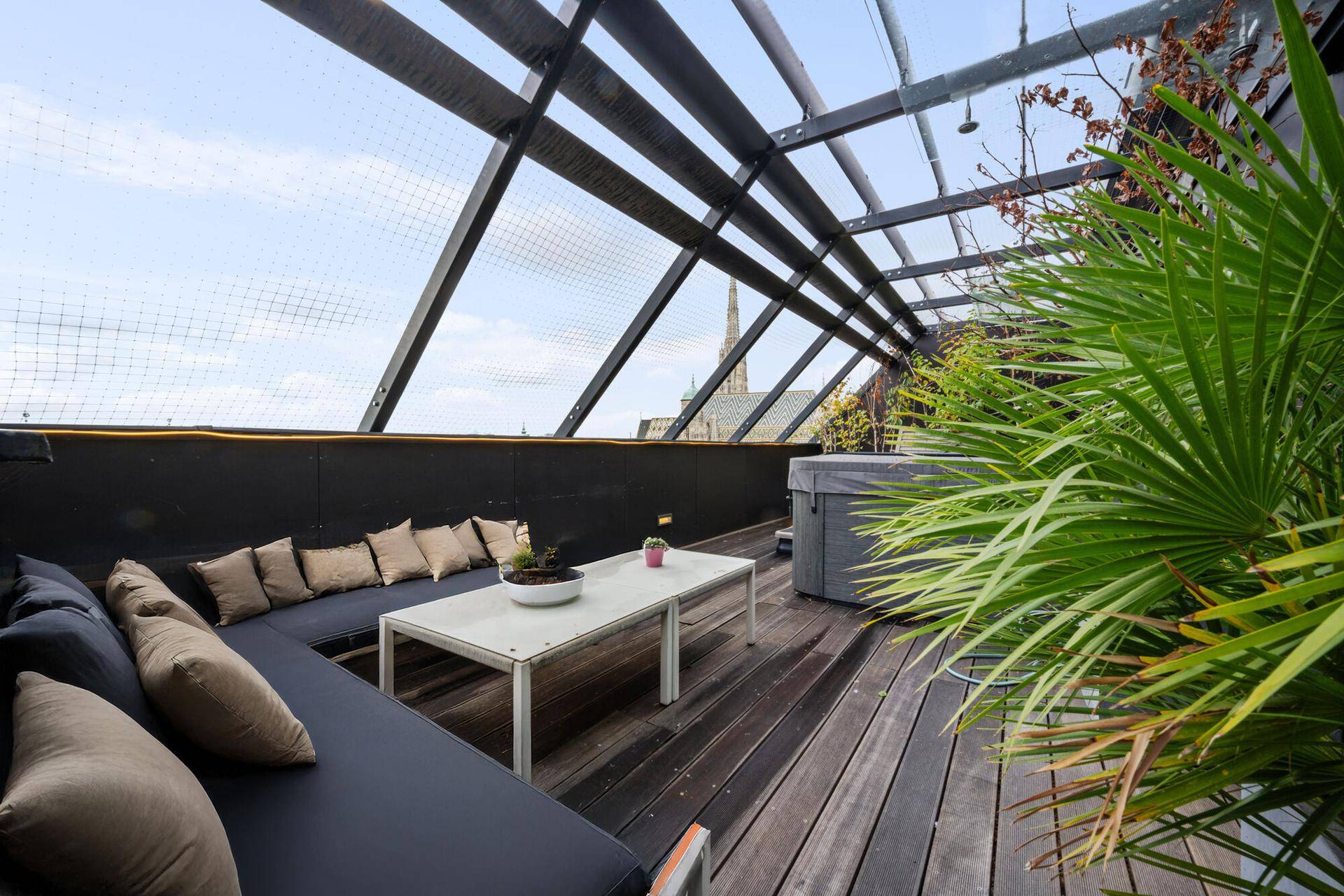 Großzügige Dachterrasse mit bequemen Sitzgelegenheiten, Whirlpool und Stadtpanorama.