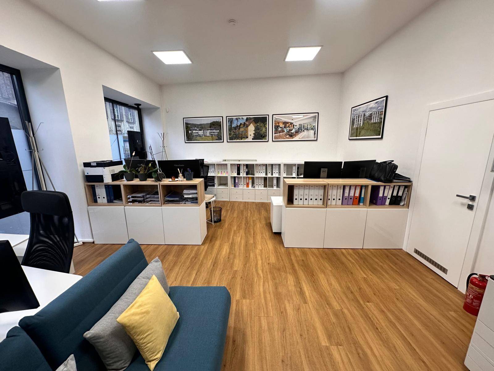 Offener Bürobereich mit mehreren Arbeitsplätzen und Stauraum.